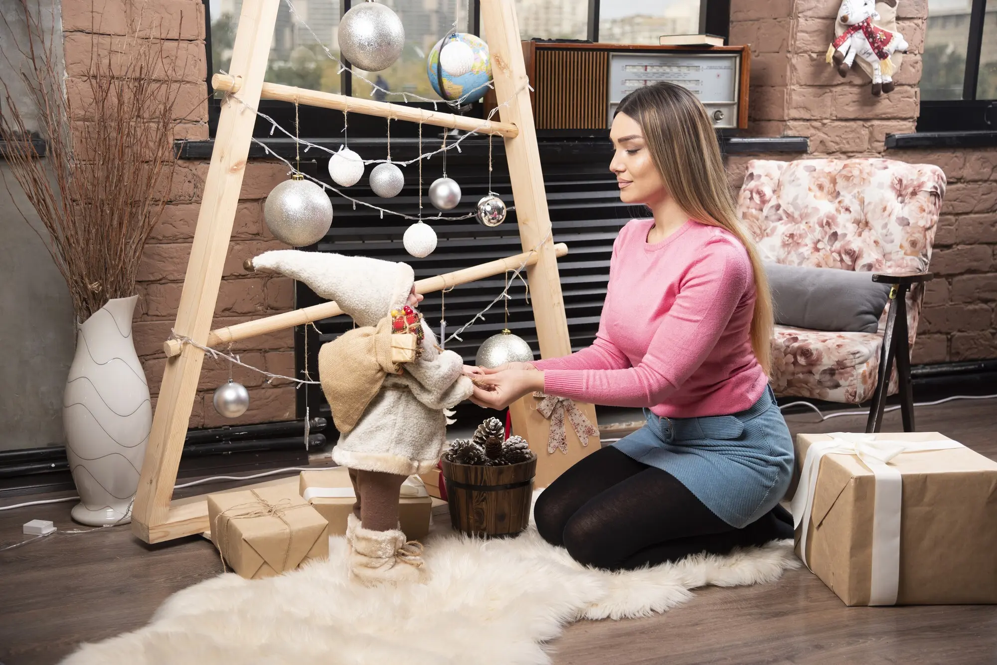 Una mujer joven y hermosa juega con una muñeca en casa.